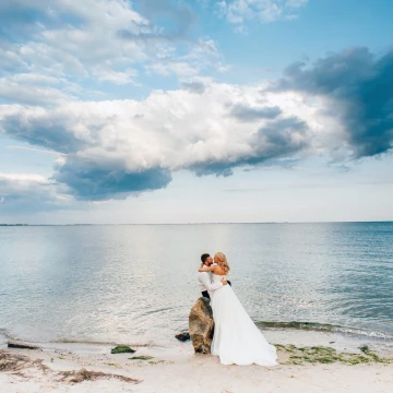 Azov Sea was especially romantic in the evening. Nature has created the perfect landscape for this beautiful couple! The bride Irina so tenderly embraces groom Eugene, as a beautiful sky reflected in the mirror of water.